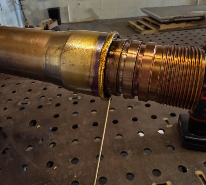 Heat-tinted weld at a threaded pipe coupling