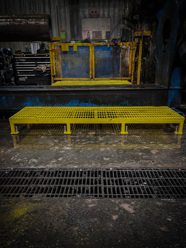 Yellow safety grating step in front of equipment